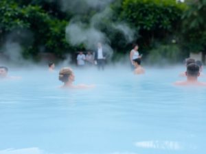 Oameni relaxându-se într-un bazin cu apă termală caldă